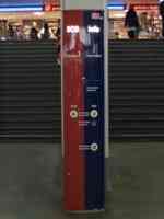 Red and blue column in train station with several buttons to call attendant