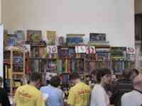 People shopping at counter and bookcases filled with games