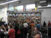 People shopping at a stall with a counter and shelves and castle decorations