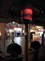 Glowing heater under umbrella at cafe